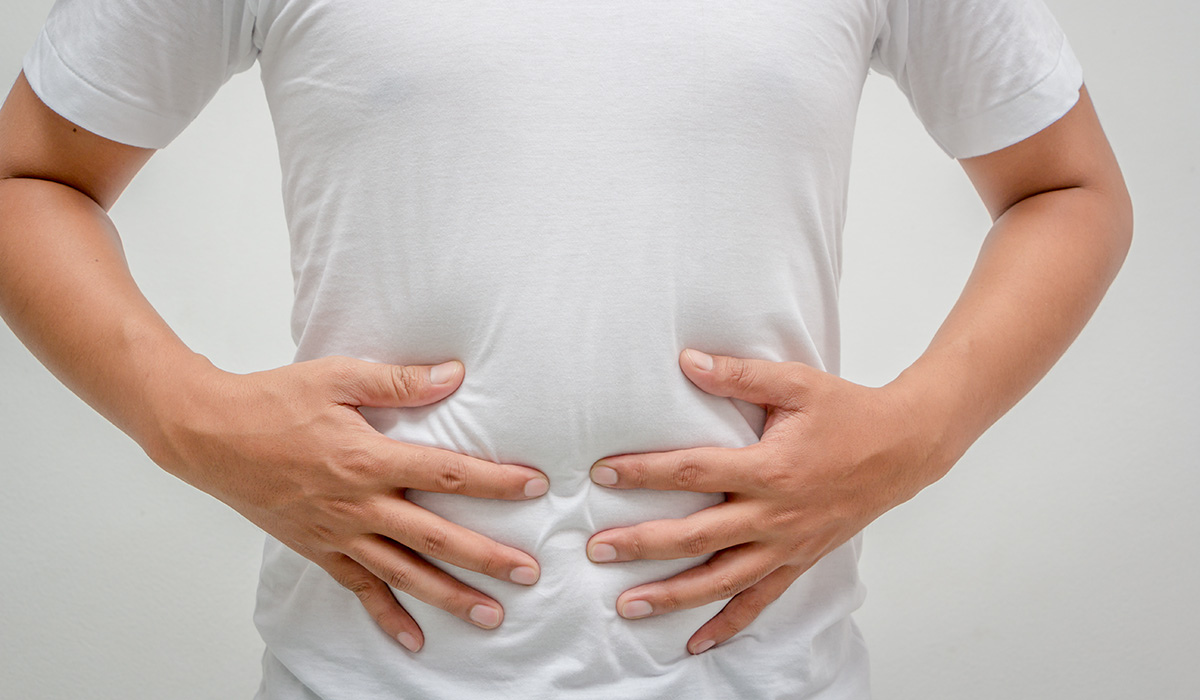 Mann fasst sich an Bauch